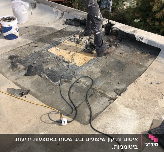 אדם קודח בגג לאיטום עם מקדחה חשמלית